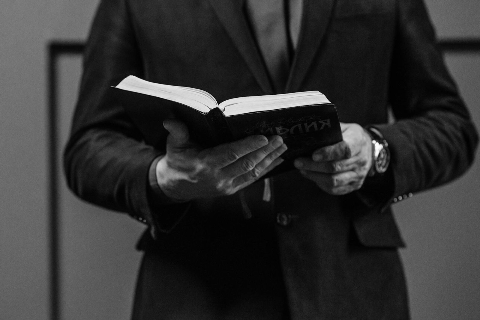a man in suit jacket holding a bible